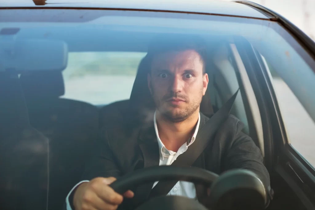 A shocked driver inside a car.