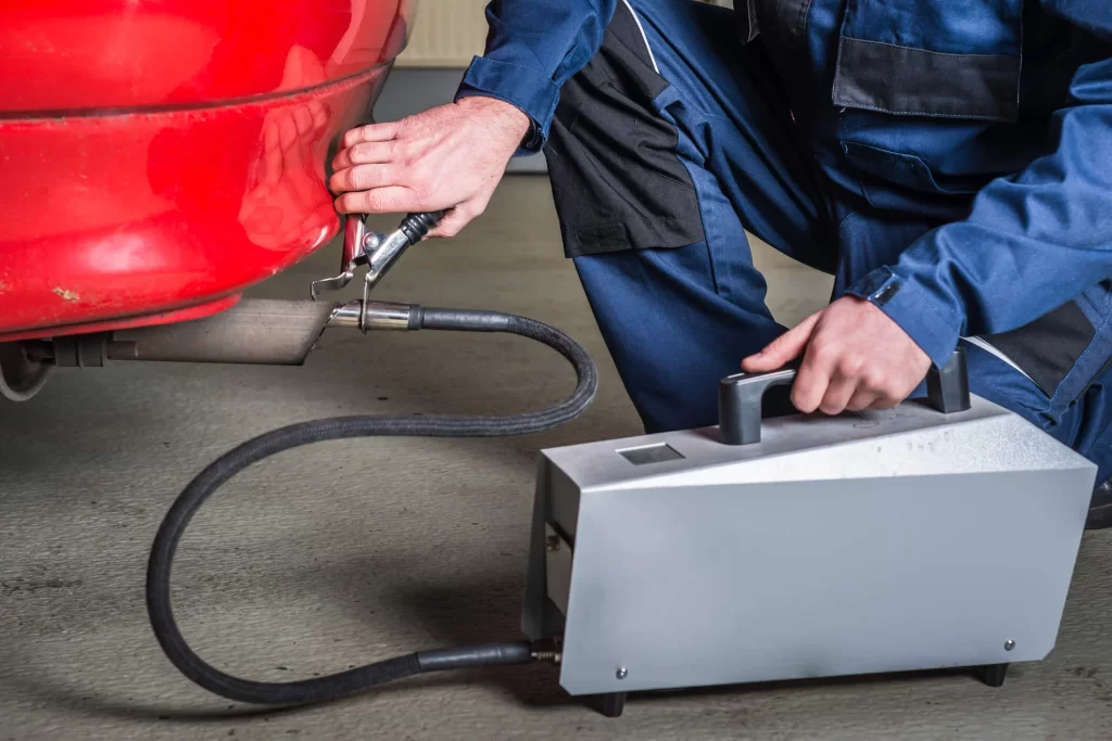A diagnostic sensor checking the exhaust gases coming out of a car's exhaust system.