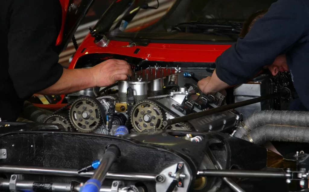 Two mechanic repair engine of sport car.