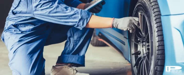 A professional car mechanic checking tire at a repair shop