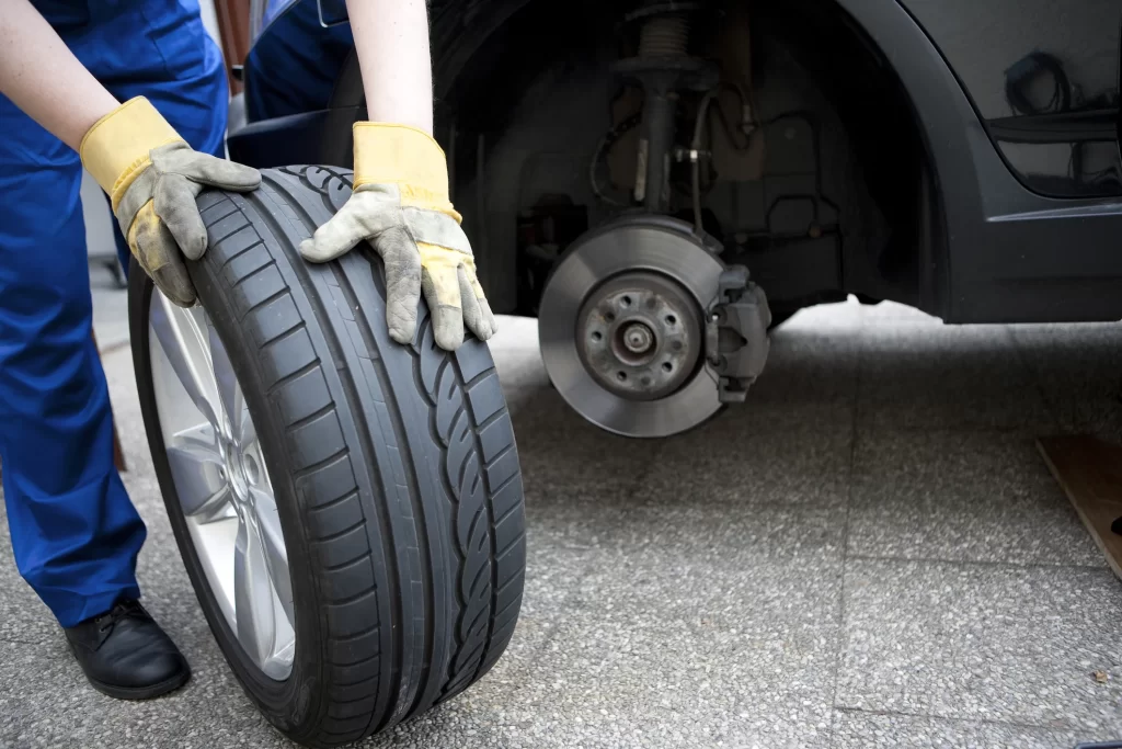 An auto mechanic working on tire replacement.