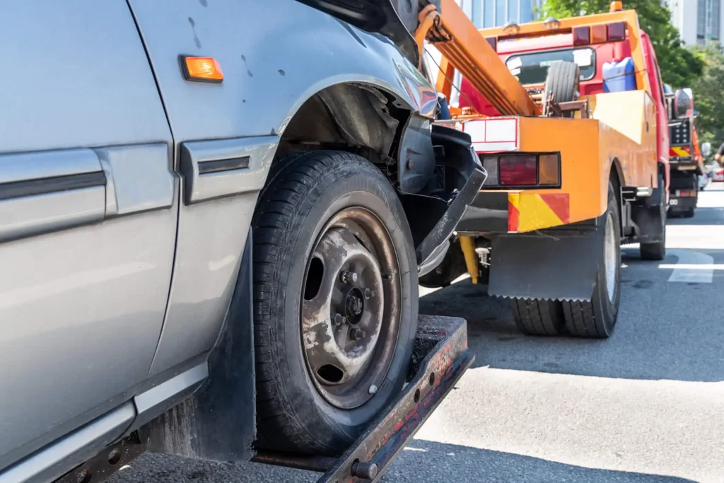 A tow truck transporting a broken-down car.