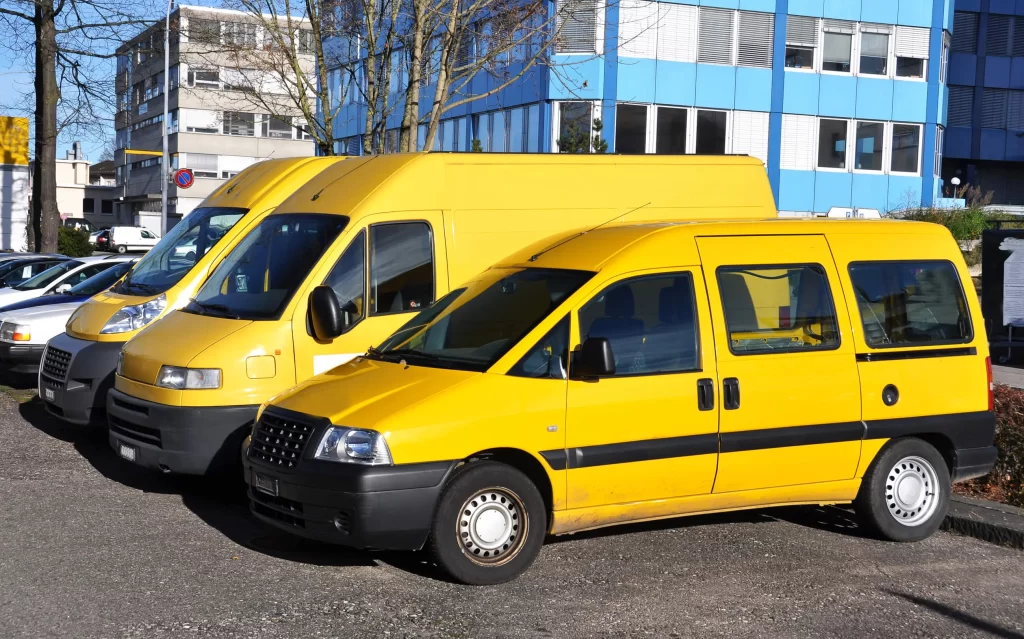 A row of yellow and white service vehicles.